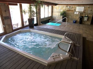Ein Whirlpool mit Holzterrasse, einem Blumentopf, einem kleinen Pool und einem Schild an der Wand.