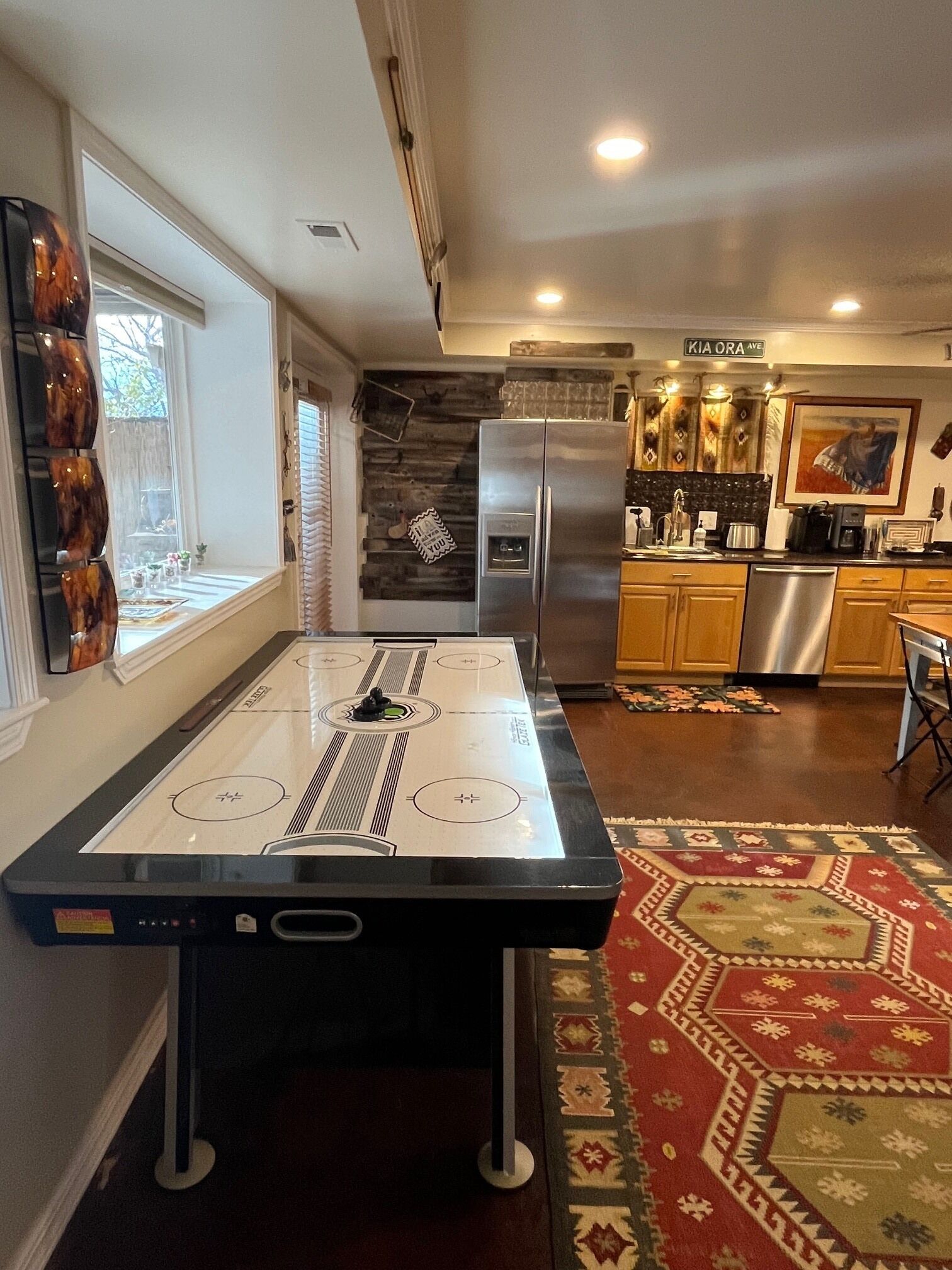 A modern kitchen with a built-in stove, stainless steel appliances, and a decorative rug.