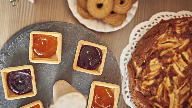 A dessert platter with various tarts and a large pie on a slate board. - Dora maison de charme (Ivrea)