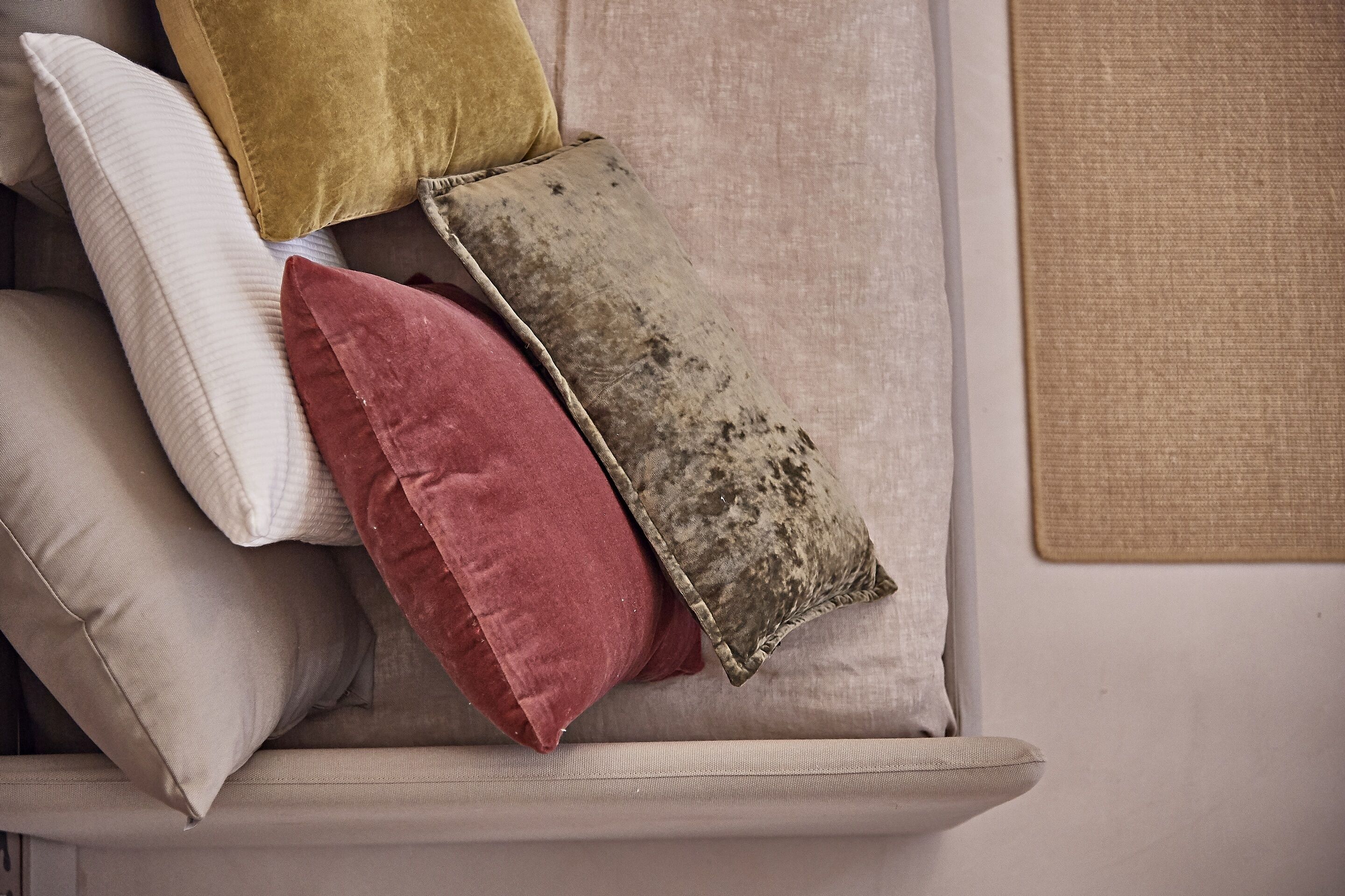 Un divano con cuscini di diverse texture e colori.