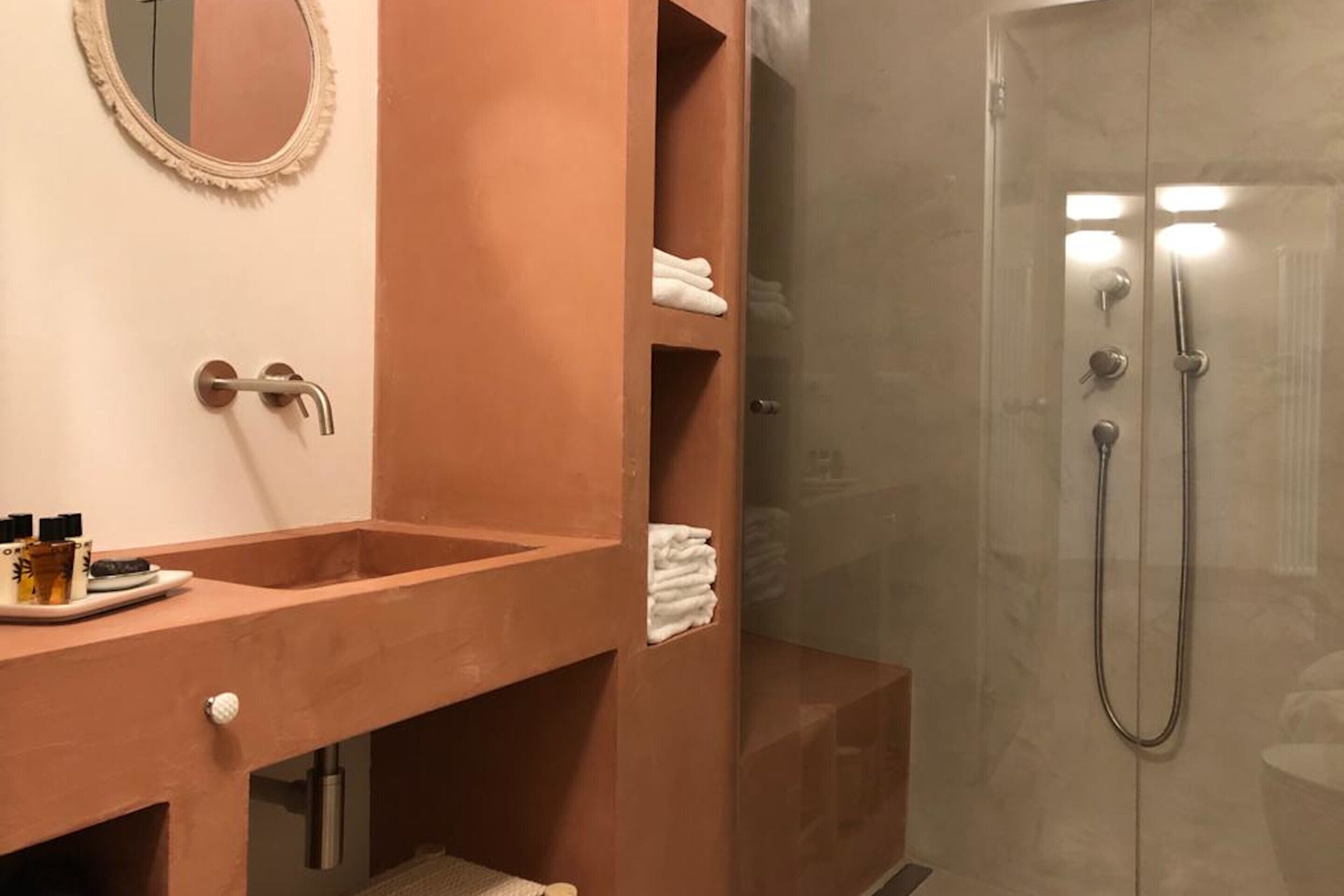A bathroom with a beige sink, a mirror, and a glass-enclosed shower.