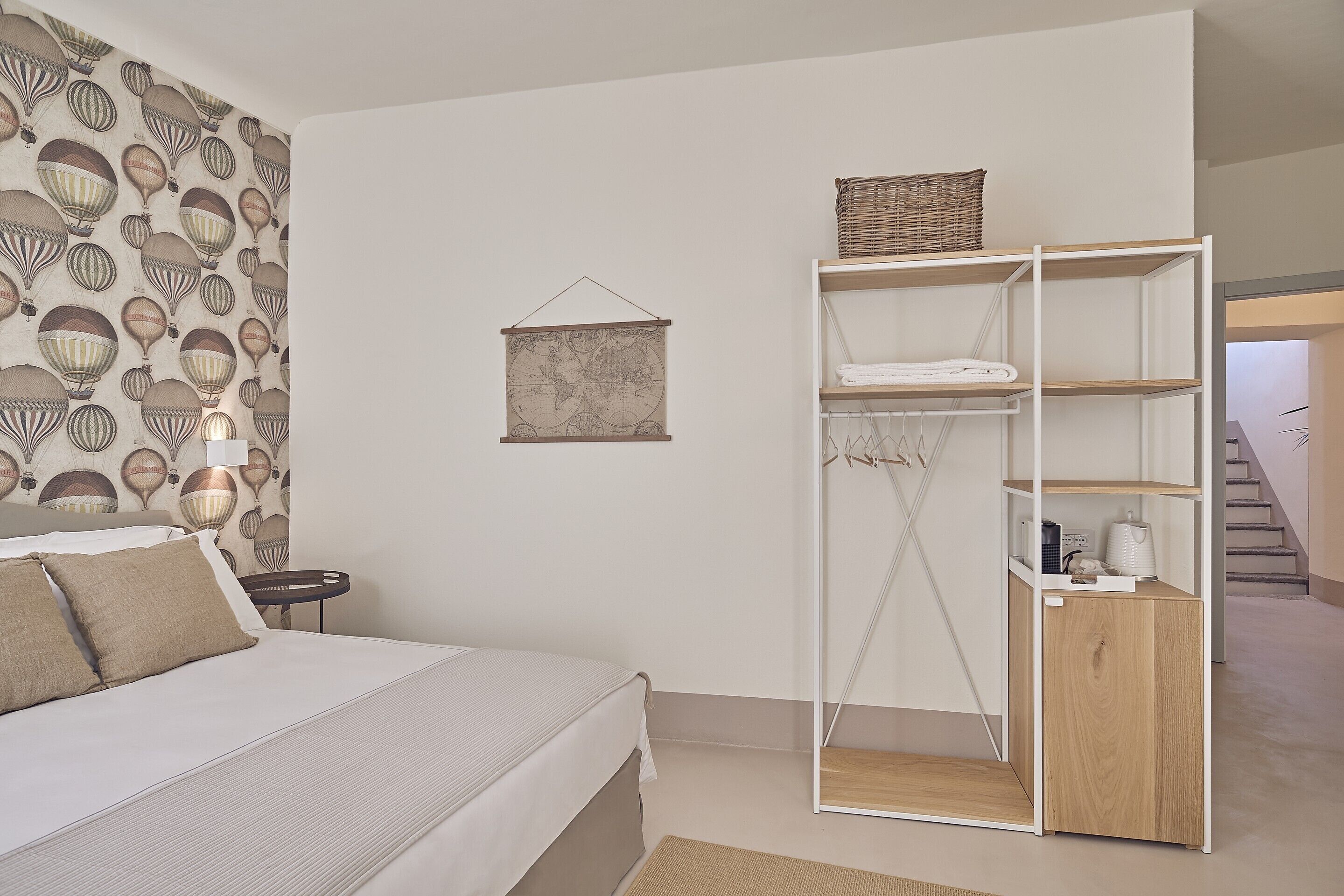 Een slaapkamer met een bed, een nachtkastje, een wandglobe en een houten kast met planken.