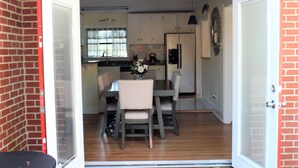 An open garage leading to a kitchen with a dining table, chairs, and a refrigerator. - COOL HAVEN- A Quiet, Elegant, Contemporary, Incognito Retreat near FAMU/FSU (Tallahassee)
