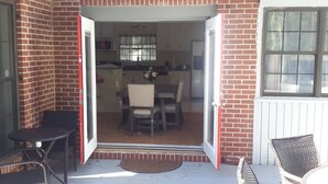 A brick exterior with a sliding glass door leading to an interior dining area with a table and chairs. - COOL HAVEN- A Quiet, Elegant, Contemporary, Incognito Retreat near FAMU/FSU (Tallahassee)