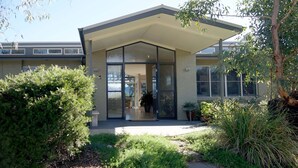 A modern building with a covered entrance, large windows, and a well-maintained garden. - Belle Bois, Capertee Valley (Bogee)