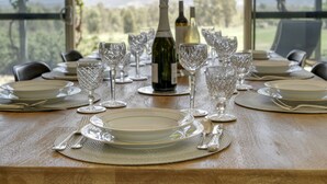A table set for a meal with wine bottles and glasses, overlooking a scenic view. - Belle Bois, Capertee Valley (Bogee)