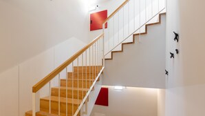 A staircase with wooden steps and white railings, leading to an upper floor. - Porto Belomonte Studios (Porto)