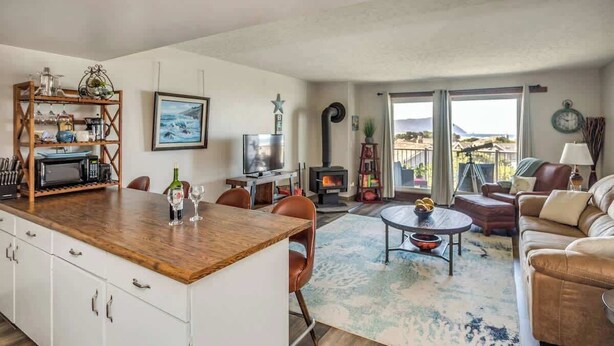 A cozy living room with a fireplace, a dining area with a wooden table and chairs, and a sofa.