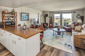 A cozy living room with a fireplace, a dining area with a wooden table and chairs, and a sofa.