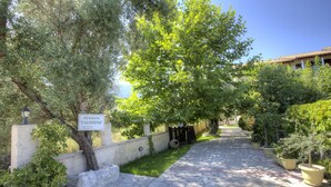 A stone pathway leading through a garden with potted plants and a sign reading "Pension 'Calderim'". - Calderimi - Lefkada Rooms (Lefkada)