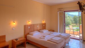 A bedroom with a large bed, wooden headboard, bedside tables, and a view of a balcony with a chair. - Calderimi - Lefkada Rooms (Lefkada)