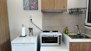 A compact kitchenette with a Bosch refrigerator, a built-in oven, a sink, and a small cabinet. - Calderimi - Lefkada Rooms (Lefkada)