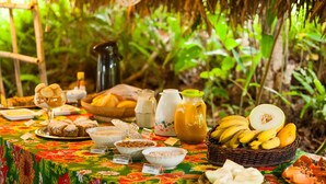 Una mesa con diferentes alimentos y una cesta de plátanos.