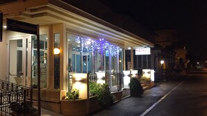 A hotel with a glass facade, outdoor lighting, and a sign indicating it is a hotel. - Hotel Dea della Salute (Bellaria-Igea Marina)