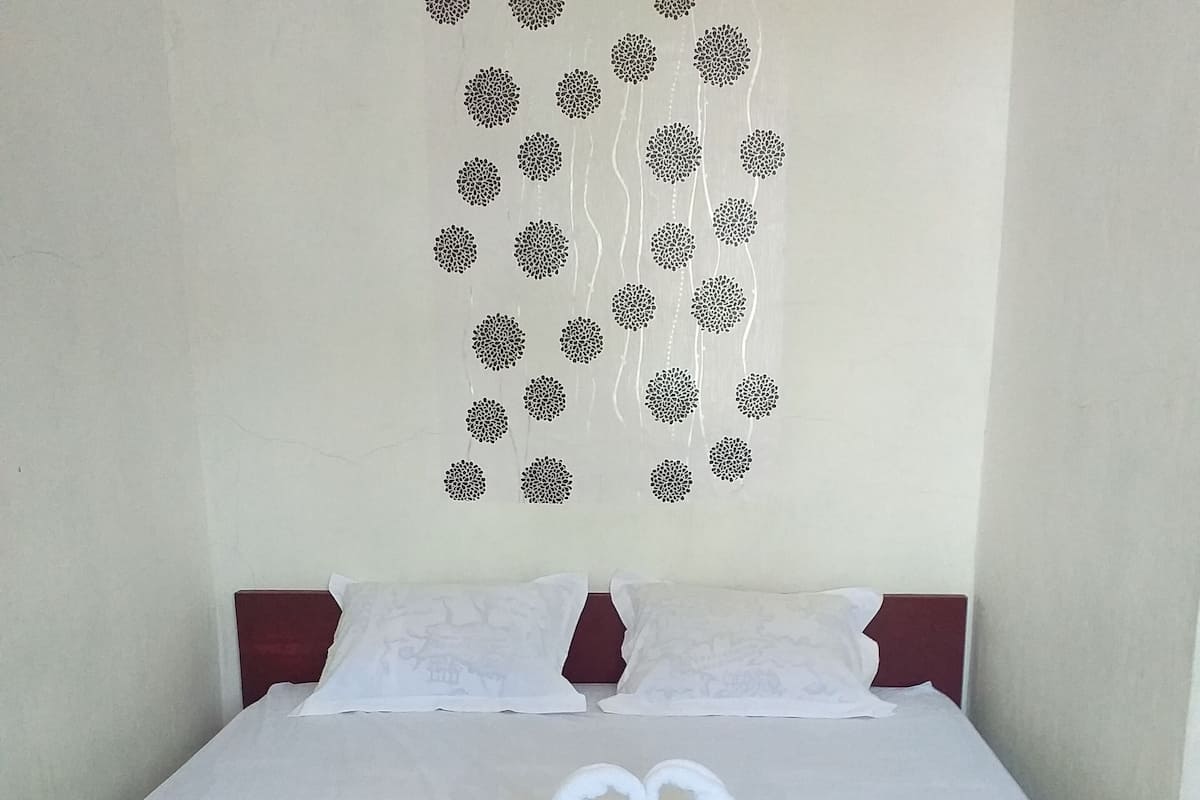 Une chambre d’hôtel avec un lit, des oreillers et une décoration murale composée de motifs circulaires.