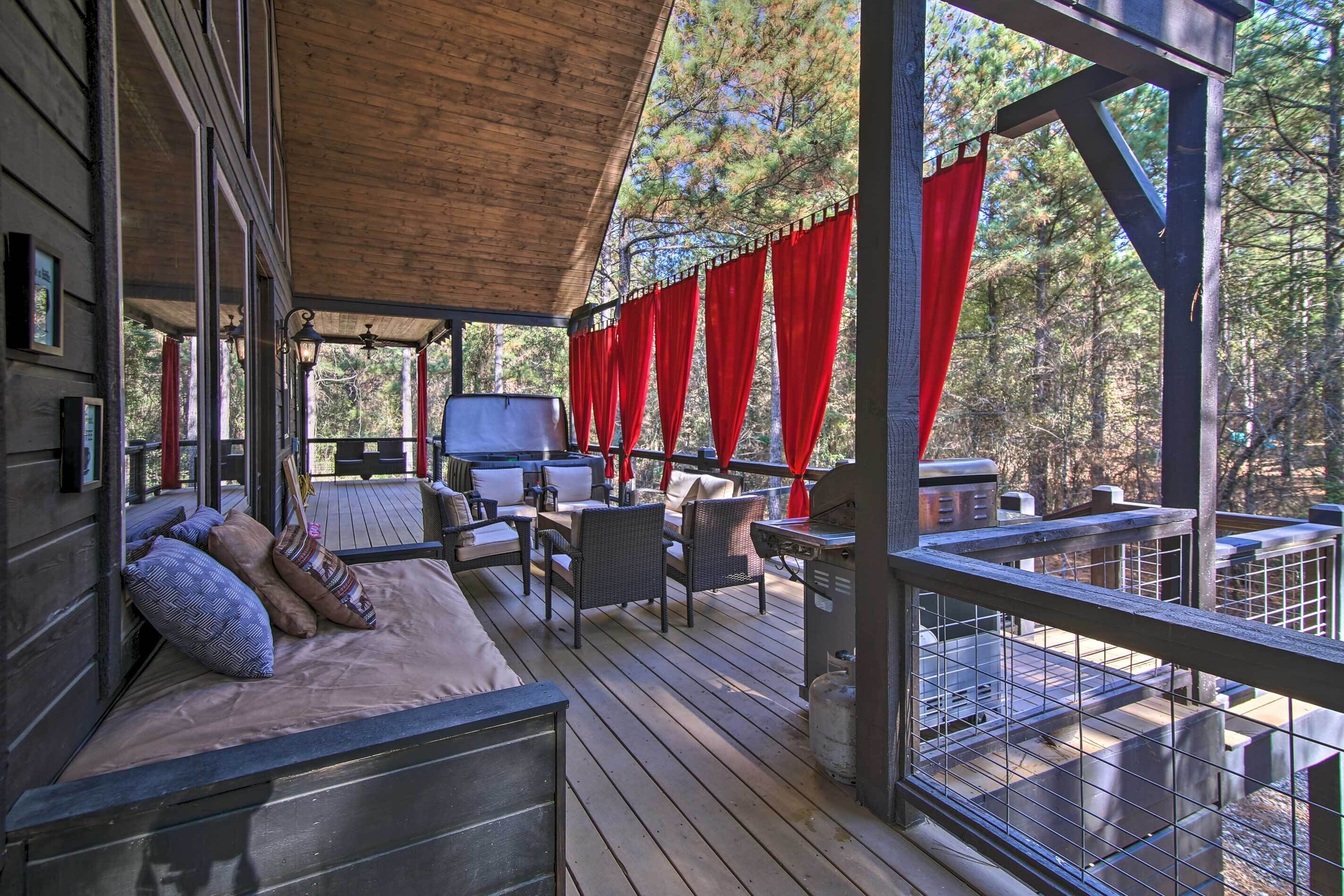 Un'area relax esterna coperta con divano, poltrone e barbecue.