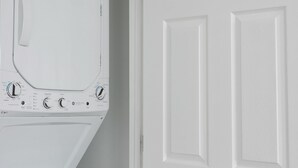 A white washing machine and dryer in a laundry room with white doors. - Bright Charming Guesthouse Close to Downtown DC (Washington)