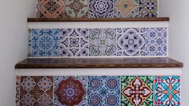 A staircase with colorful, patterned tiles and a potted plant at the top. - Bright Charming Guesthouse Close to Downtown DC (Washington)