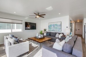 A modern living room with a sofa, coffee table, and a ceiling fan.