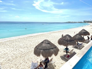 Privatstrand, weißer Sandstrand, Liegestühle, Sonnenschirme