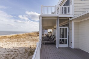 Propiedad frente a la playa con terraza techada, asientos al aire libre y vista a la playa y al océano.