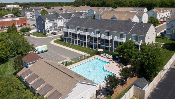 A residential building with a swimming pool, multiple balconies, and a parking area. - BIKE TO REHOBOTH & LEWES BEACHES & RESTAURANTS, 19781 Keystone Dr., Rehoboth (Rehoboth Beach)