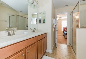 Une salle de bain avec un grand meuble-lavabo, deux éviers et un miroir.