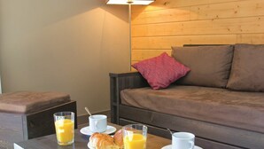 Um quarto acolhedor com uma mesa de centro de madeira, um sofá e uma luminária.