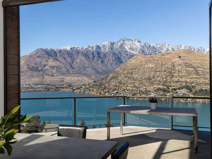 A balcony with a clear view of a lake and mountains.