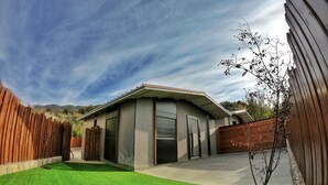 A modern house with a garage, a well-maintained lawn, and a wooden fence. - The Getaway (Hrajel)
