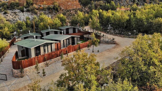 A modern resort with multiple buildings, a gravel driveway, and a surrounding natural landscape. - The Getaway (Hrajel)