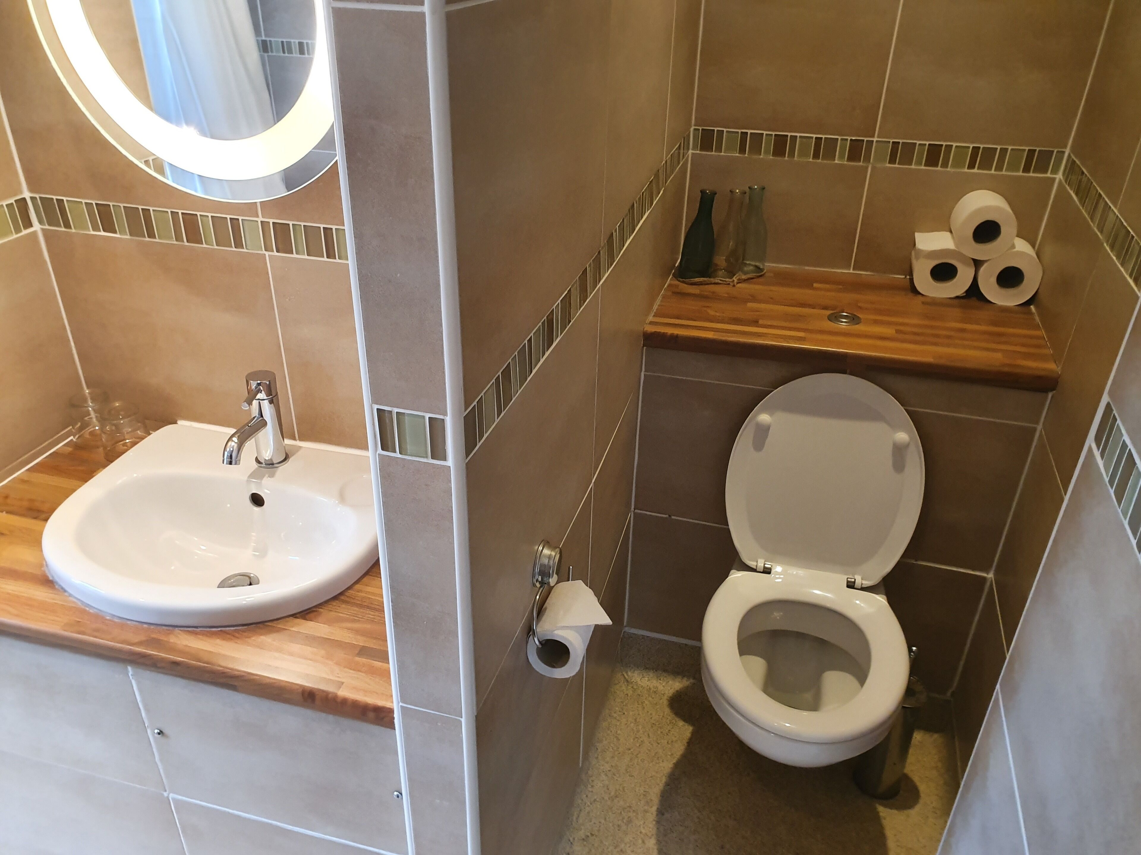 A bathroom with a sink, toilet, and a mirror.