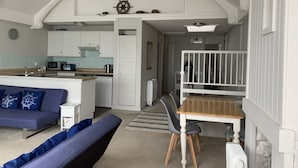 A compact living space with a kitchenette, a dining area, and a sofa. - Halfway House Inn (Torpoint)
