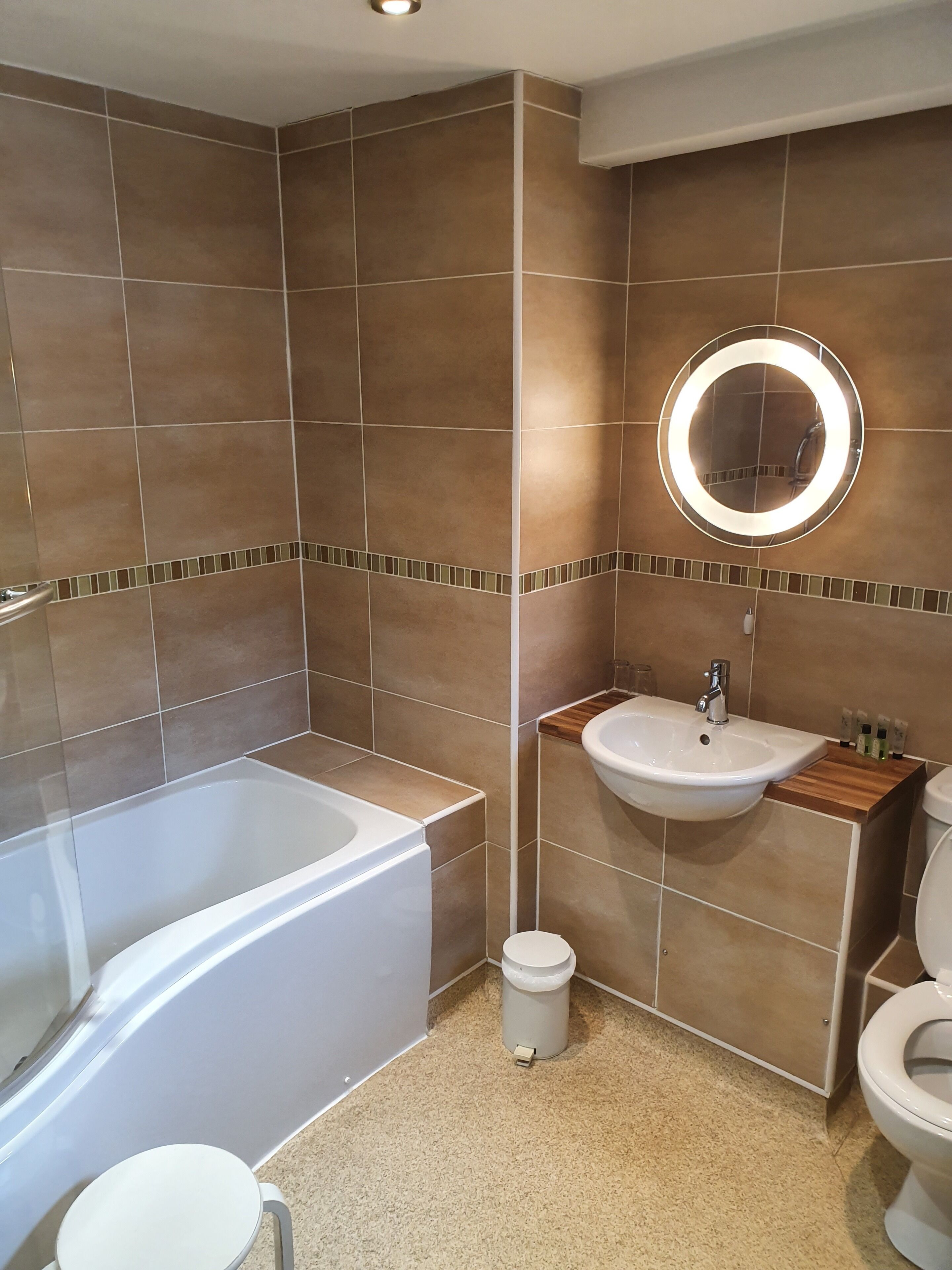 Un bagno moderno dotato di vasca, lavabo e servizi igienici.