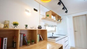 Eine moderne Küche mit Holzböden, einem eingebauten Backofen und einem Fenster über der Spüle.