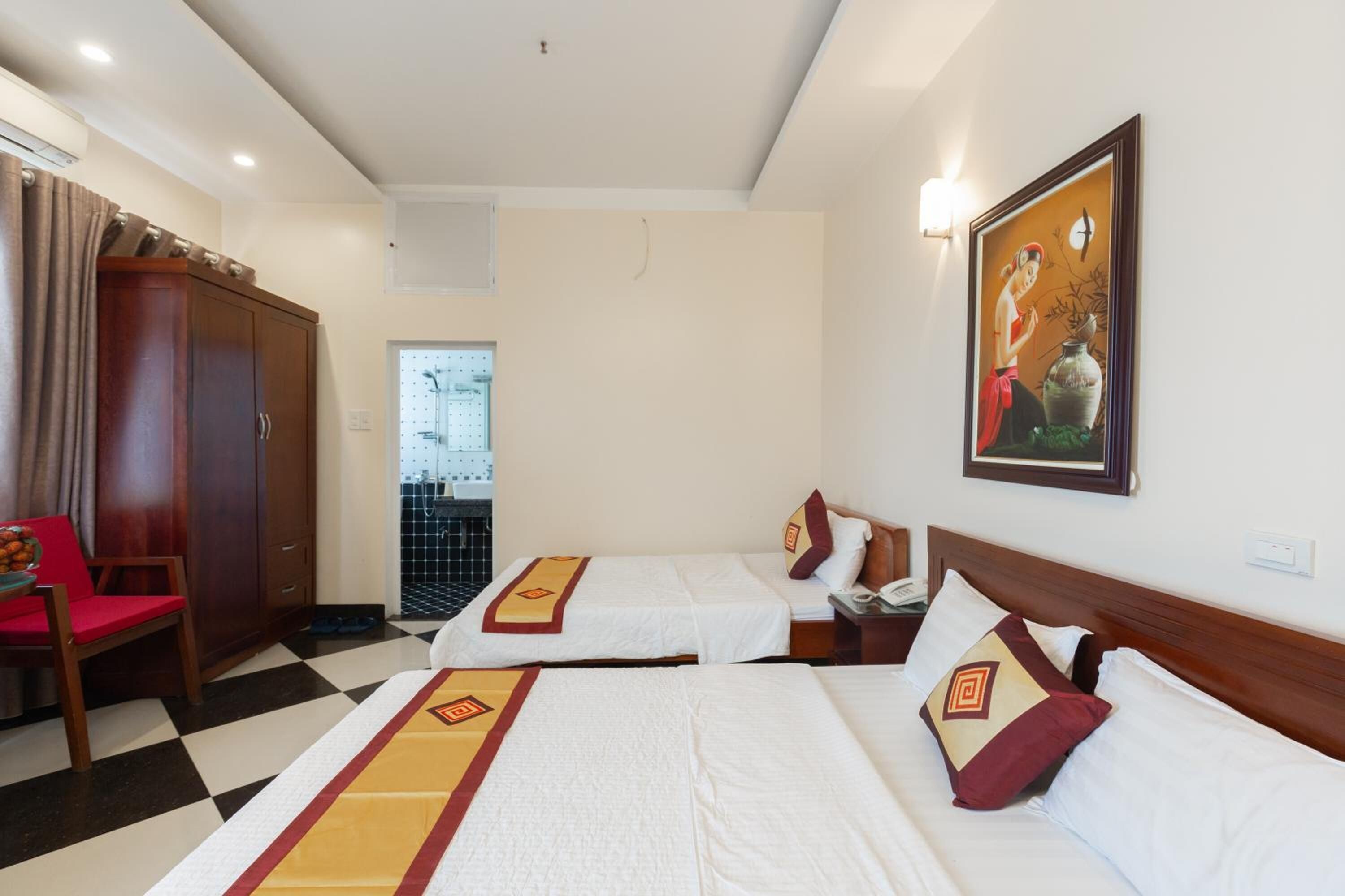 A hotel room with two beds, a wardrobe, a desk, and a chair.