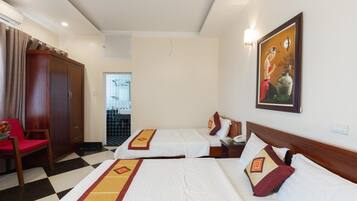 A hotel room with two beds, a wardrobe, a desk, and a chair.