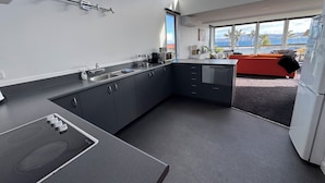 Eine moderne Küche mit Einbauherd, Spüle und Fenster mit Blick auf eine reizvolle Landschaft.