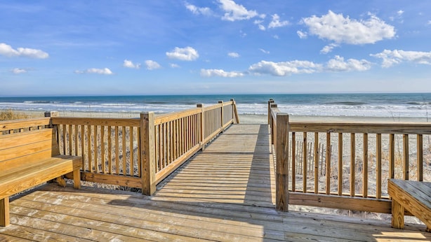 A wooden boardwalk leading to a beach with a wooden bench on the left and a wooden railing on the right. - 3 Mi to Ocean: Resort Condo in Myrtle Beach! (Myrtle Beach)