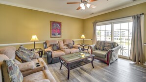A living room with two sofas, a glass coffee table, and two lamps. - 3 Mi to Ocean: Resort Condo in Myrtle Beach! (Myrtle Beach)