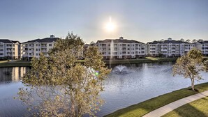 A row of multi-story residential buildings with a body of water in the foreground and a clear sky. - 3 Mi to Ocean: Resort Condo in Myrtle Beach! (Myrtle Beach)