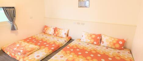 Habitación de hotel con dos camas individuales, cada una con ropa de cama y almohadas estampadas con motivos florales.