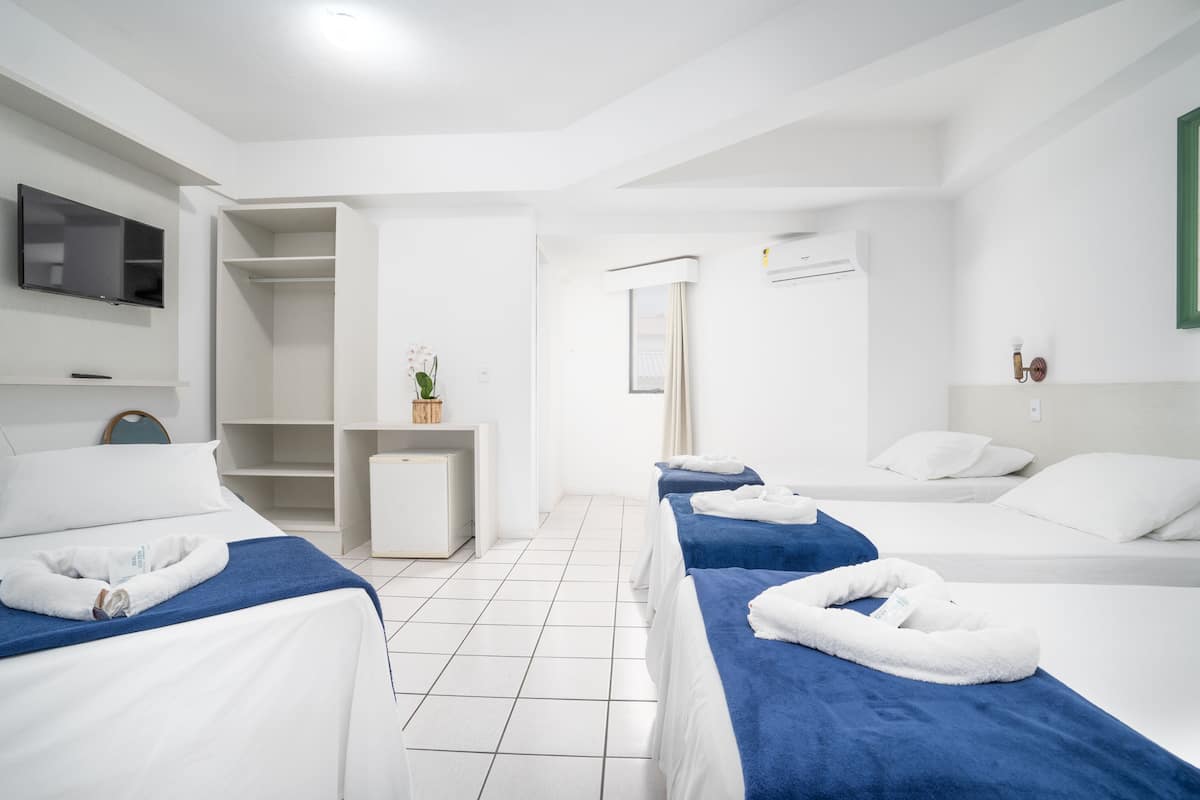 Une chambre d’hôtel avec deux lits, un bureau, une télévision et une salle de bain.