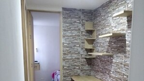 Ein kleines Schlafzimmer mit Einbauschrank, Nachttisch und kleinem Fenster.