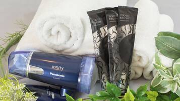 A Panasonic hair dryer, white towels, and a set of toothbrushes.