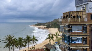 A beachfront hotel with multiple balconies, large windows, and a view of the ocean. - Mira Bai Xep Quy Nhon - The Hidden Jewel - Hostel (Quy Nhon Nam)