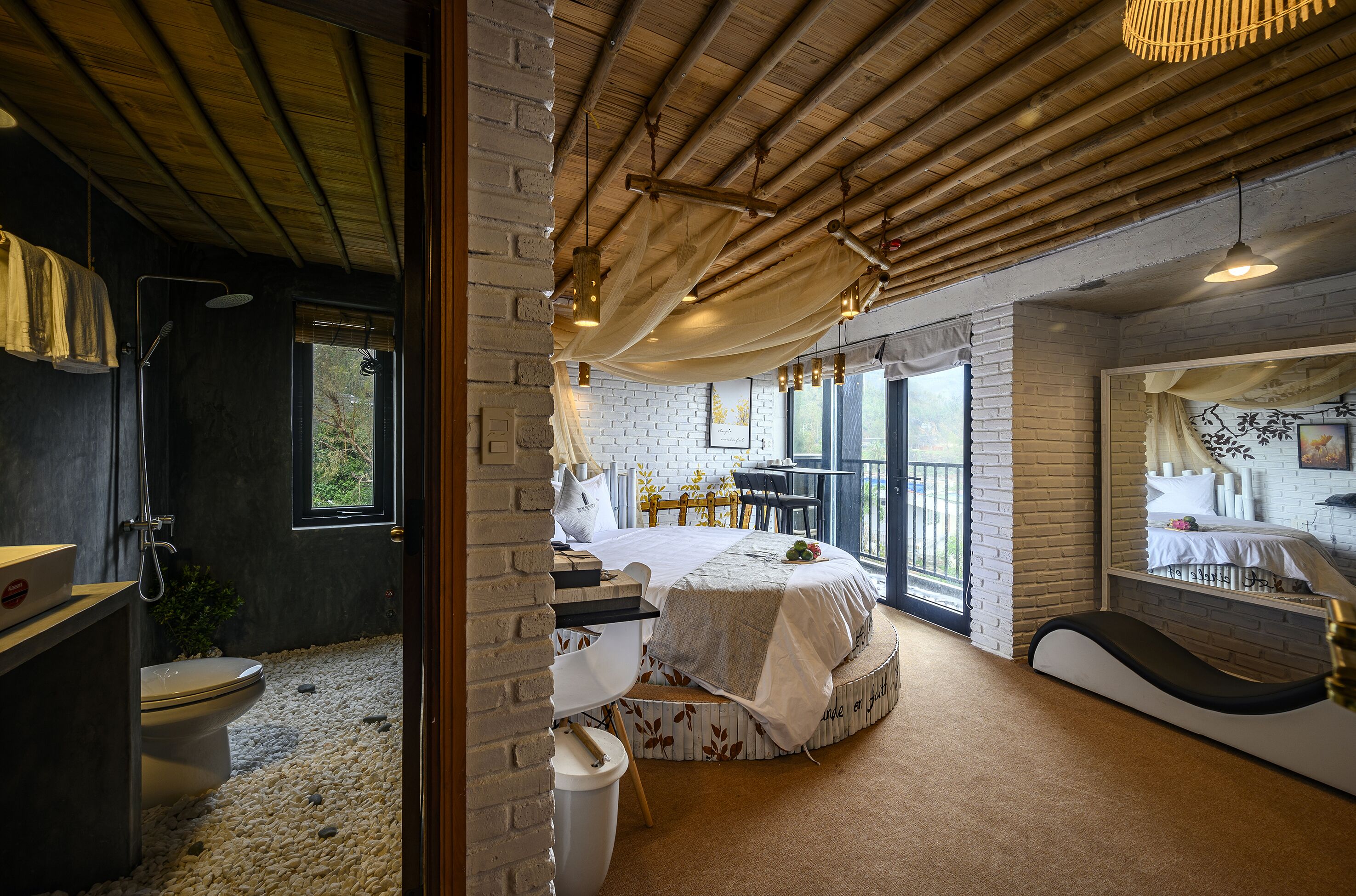 Un dormitorio con cama, escritorio, silla, ventana y baño.