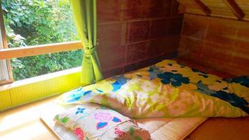 Una habitación acogedora con cama, ventana con cortinas y vistas a zonas verdes.