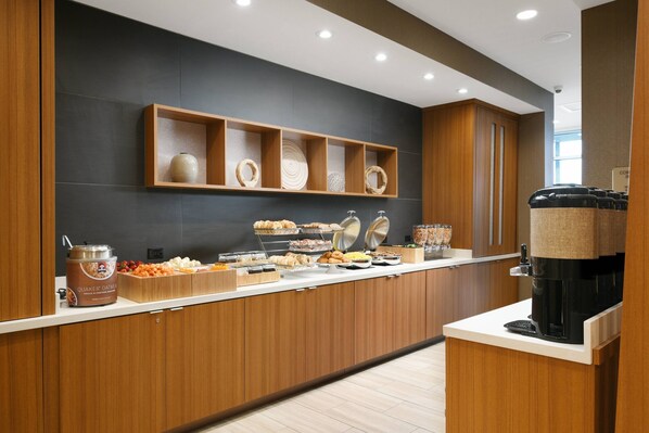 A breakfast buffet with various food items and a coffee machine.