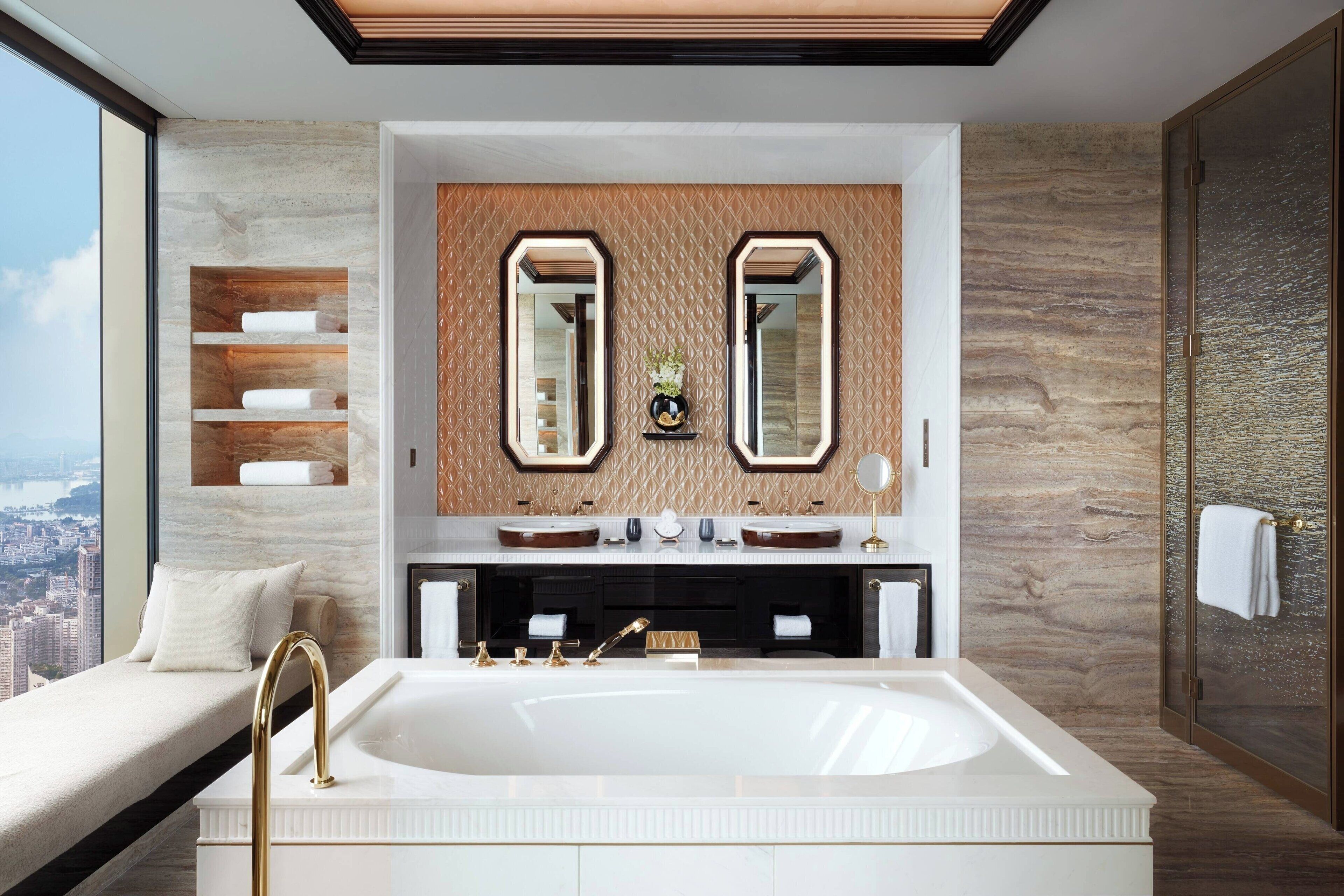 A modern bathroom with a large bathtub, dual sinks, and a large mirror above.